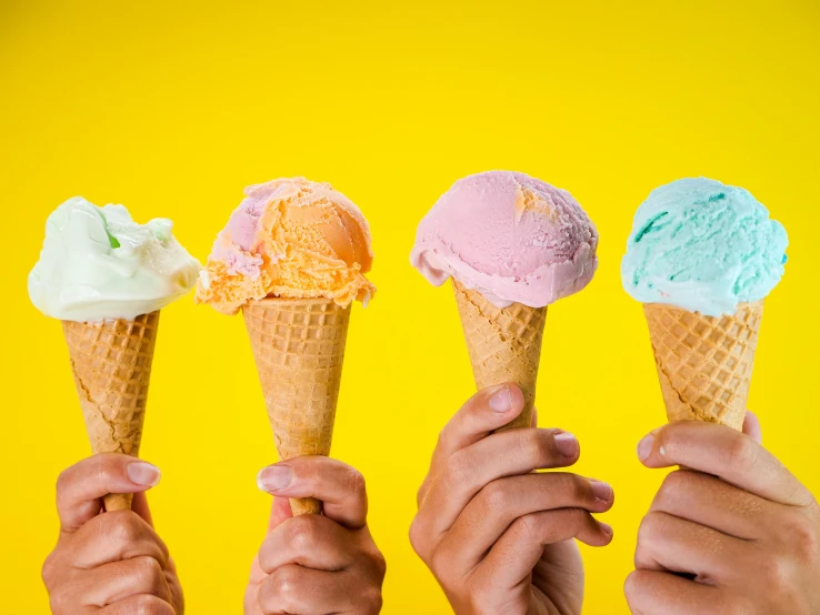 a group of people holding up ice cream cones, a pastel, by Dan Content, trending on pexels, yellow, 4 colors, edible, background image