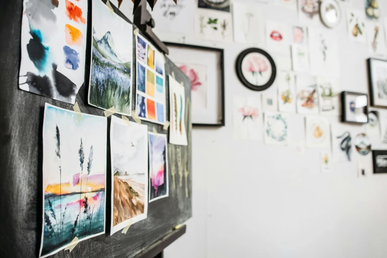 a bunch of pictures hanging on a wall, a watercolor painting, trending on unsplash, academic art, 9 9 designs, in a studio, studio shot