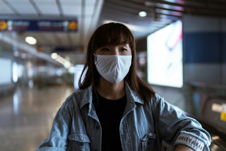 a woman wearing a face mask at an airport, a picture, inspired by Fei Danxu, pexels contest winner, hyperrealism, portrait of max caulfield, shot with sony alpha 1 camera, south korean male, an all white human