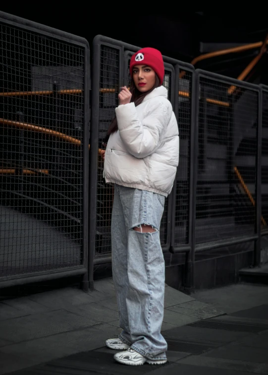 a woman in a white jacket and a red hat, inspired by Elsa Bleda, trending on pexels, baggy jeans, puffer jacket, menacing pose, instagram picture