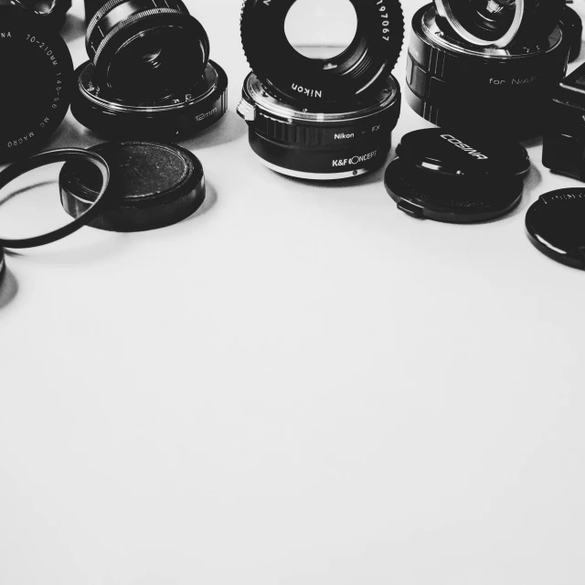 a bunch of cameras sitting on top of a table, a black and white photo, technological rings, black color on white background, sigma lens photo