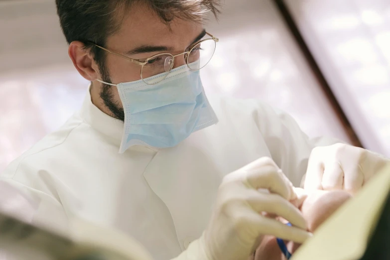 a man in a lab coat working on a piece of paper, pexels contest winner, hyperrealism, uniform teeth, avatar image, brown, facemask