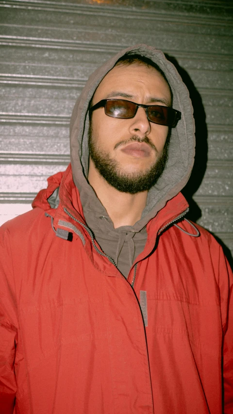 a man in a red jacket and sunglasses, an album cover, by Pablo Rey, unsplash, in a hoodie, late 2000’s, paulie shore, headshot