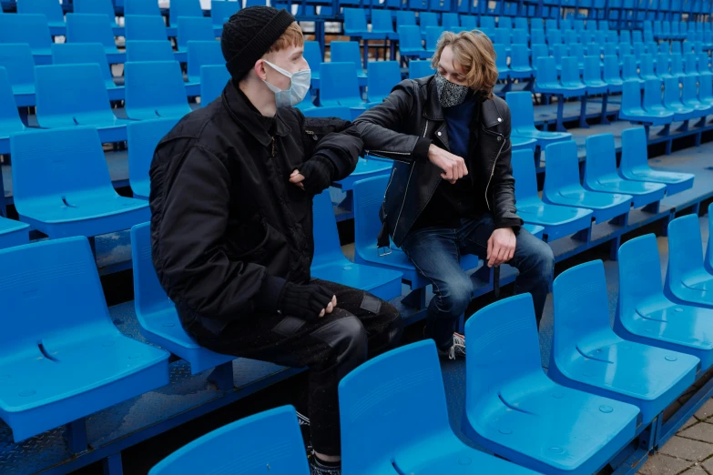 a couple of people sitting on top of blue chairs, pexels, conceptual art, surgical mask covering mouth, soccer player matthijs de ligt, wearing jeans and a black hoodie, avatar image