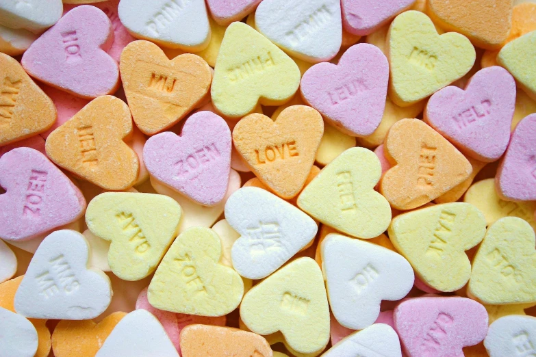 a pile of candy hearts sitting on top of each other, 🍸🍋, history, up-close, screensaver