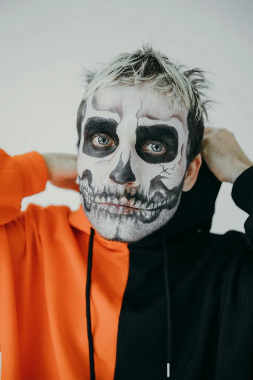 a man with a skeleton face painted on his face, an album cover, inspired by Seb McKinnon, trending on pexels, blonde guy, pewdiepie, black and orange, lil peep