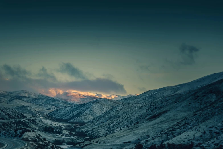 a snow covered mountain with a road going through it, inspired by Elsa Bleda, les nabis, landscape wallpaper, sunset in a valley, blue, dark