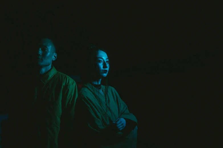 two men standing next to each other in the dark, inspired by Elsa Bleda, pexels contest winner, ruan jia and fenghua zhong, portrait of two people, demna gvasalia, green ambient light