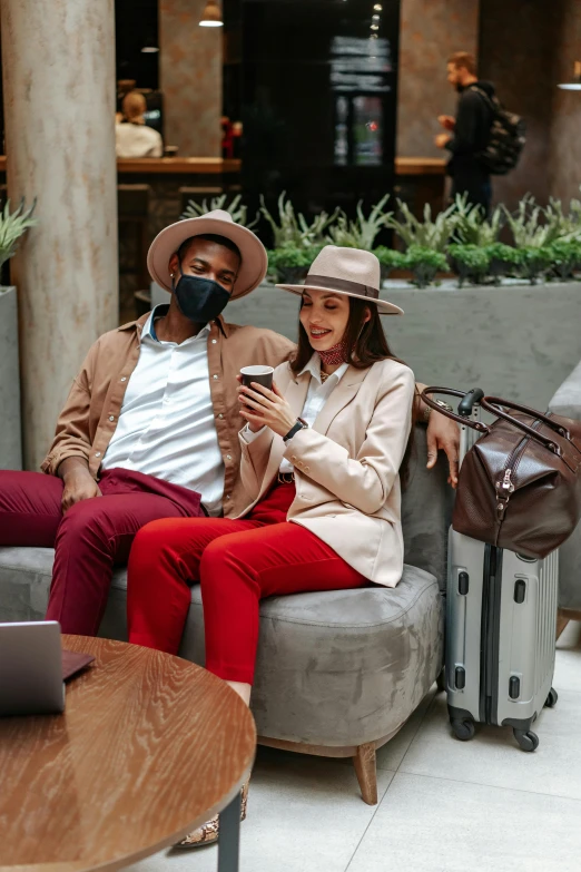 a couple of people that are sitting on a couch, trending on pexels, renaissance, caracter with brown hat, luggage, masking, professional comercial vibe