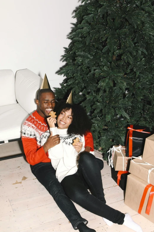 a man and woman sitting in front of a christmas tree, ashteroth, celebrating a birthday, chilling, sturdy