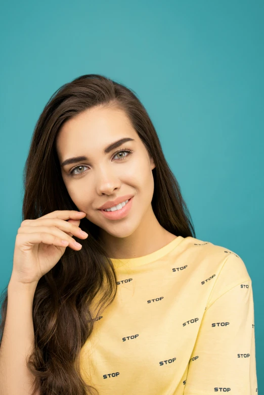 a beautiful young woman posing against a blue background, trending on pexels, portrait sophie mudd, 15081959 21121991 01012000 4k, straight teeth, yellow