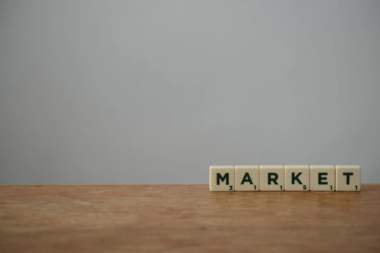 a wooden block with the word market written on it, by Mark Poole, trending on pexels, photorealism, minimalist logo without text, portrait of mario, age marks, stark light