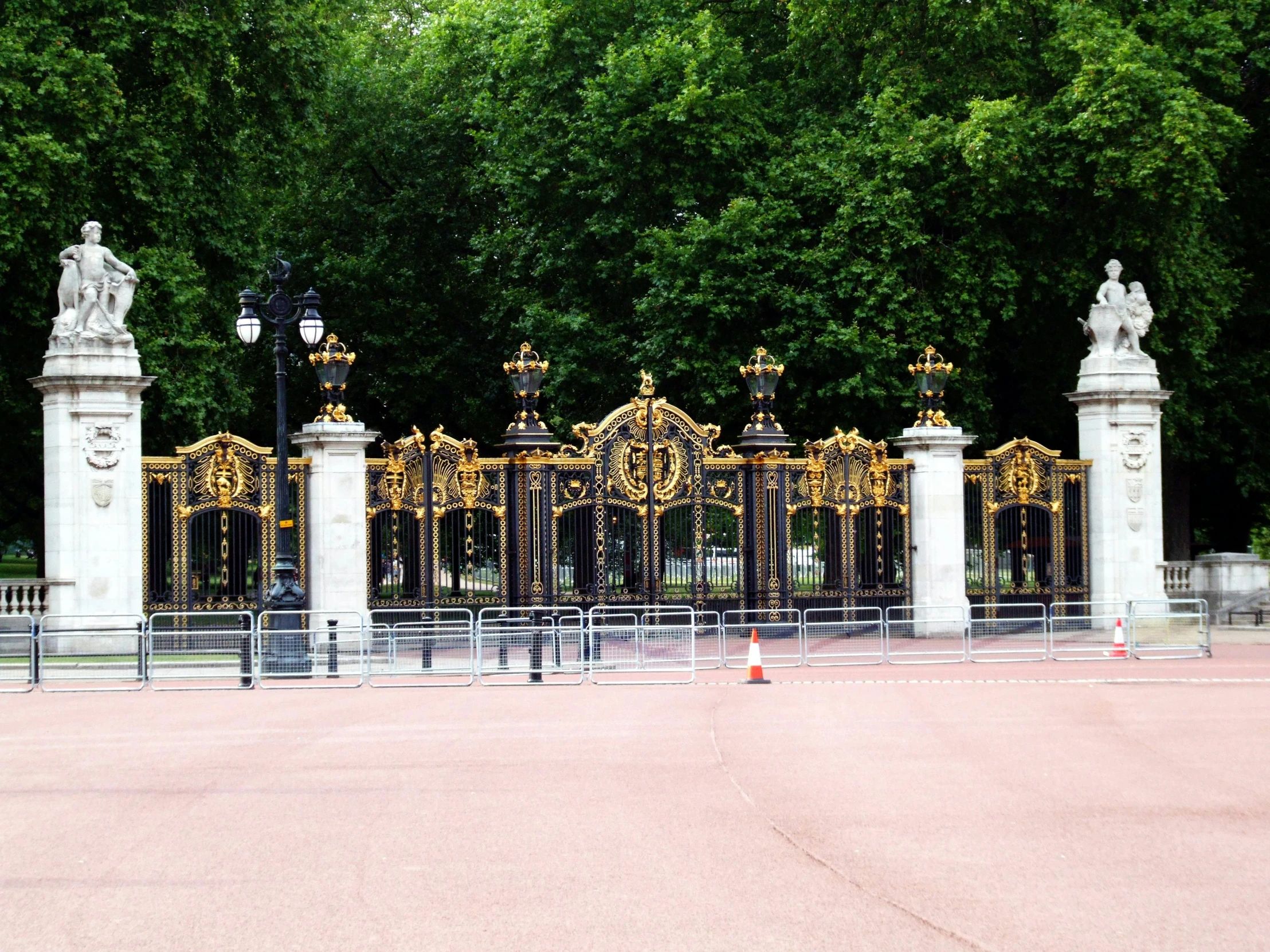 a large gate in the middle of a park, royally decorated, shining gold and black and red, 🦩🪐🐞👩🏻🦳, walking down