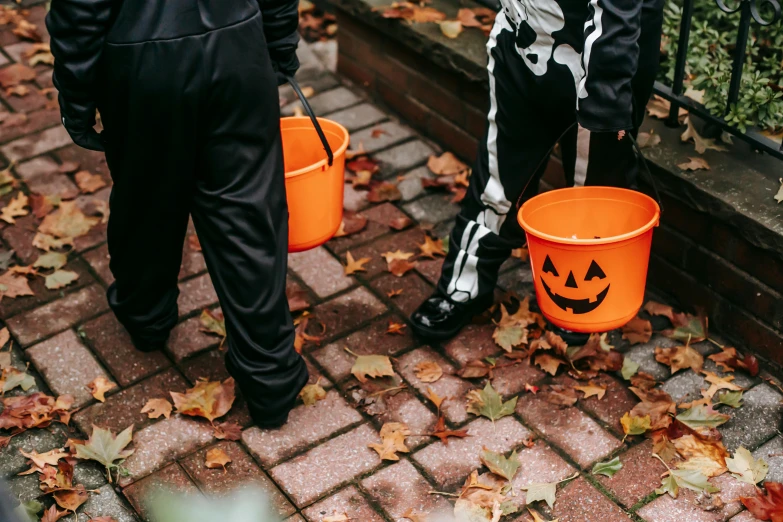 a couple of kids in halloween costumes standing next to each other, pexels, cauldrons, head down, gif, walking down