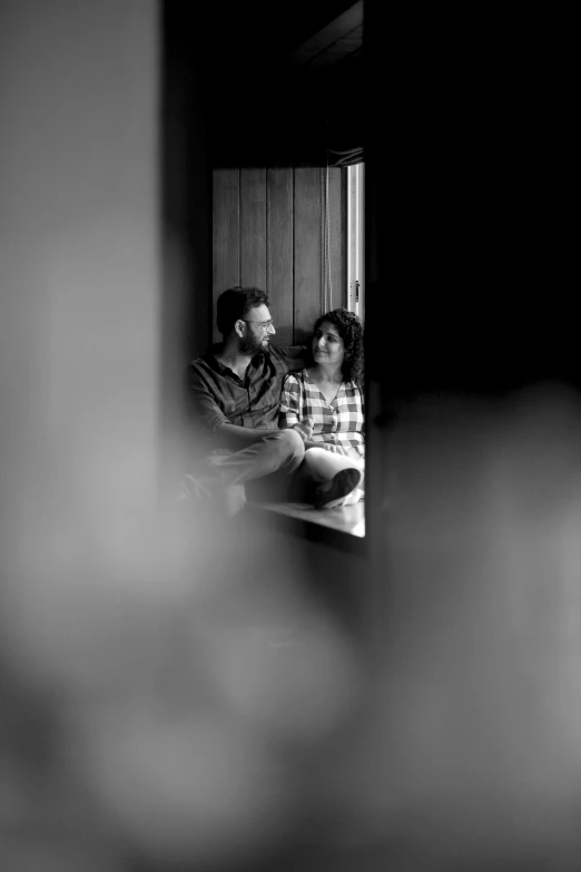 a man and a woman sitting on a couch, a black and white photo, by Max Dauthendey, looking through a window frame, captured on canon eos r 6, square, true love