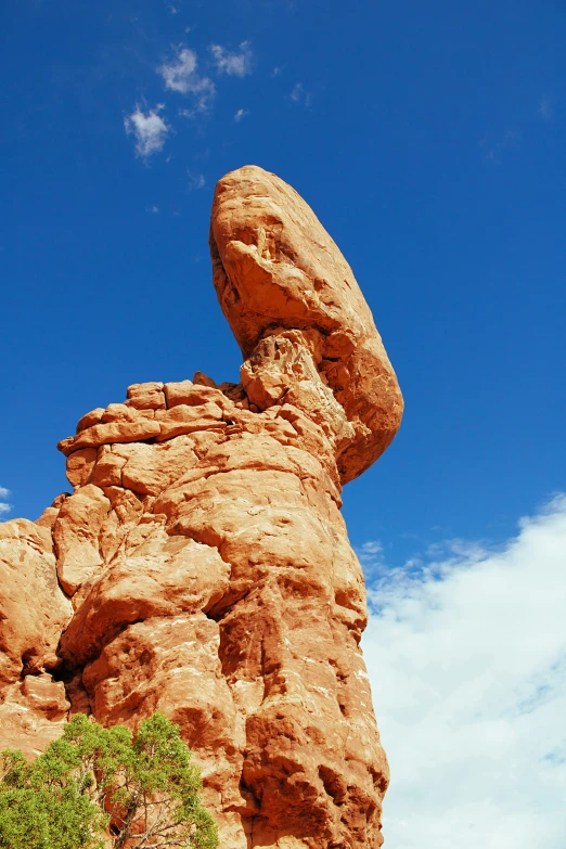 a large rock formation in the middle of a desert, a statue, arabesque, blue skies, moab, slide show, stacked image