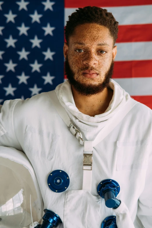 a man standing in front of an american flag, an album cover, inspired by Jules Tavernier, wearing a space suit, tyler miles lockett, close - up portrait shot, white uniform