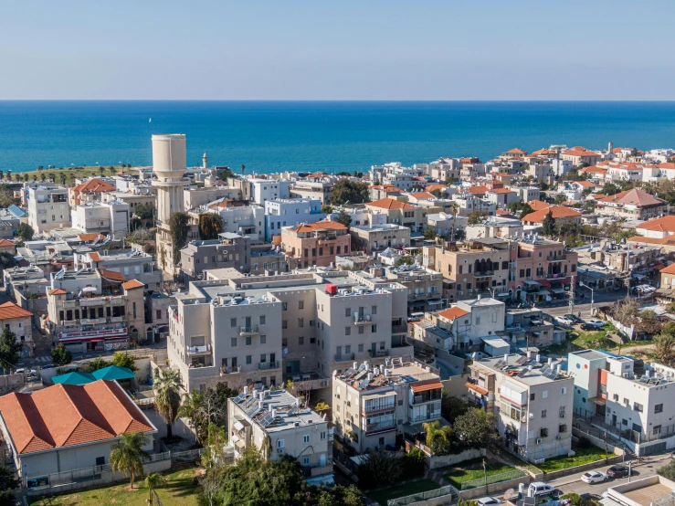 an aerial view of a city next to the ocean, israel, square, quaint, commercial photo