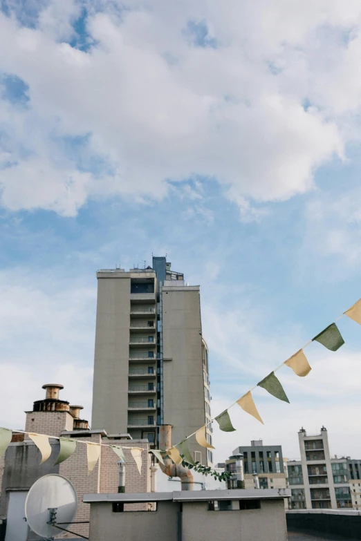 a satellite dish sitting on top of a roof next to a tall building, an album cover, inspired by Zhang Kechun, unsplash, prayer flags, wedding, waikiki beach skyline, ignant