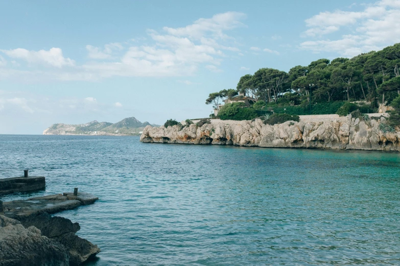 a body of water surrounded by rocks and trees, unsplash, les nabis, mediterranean beach background, harbour, conde nast traveler photo, john pawson