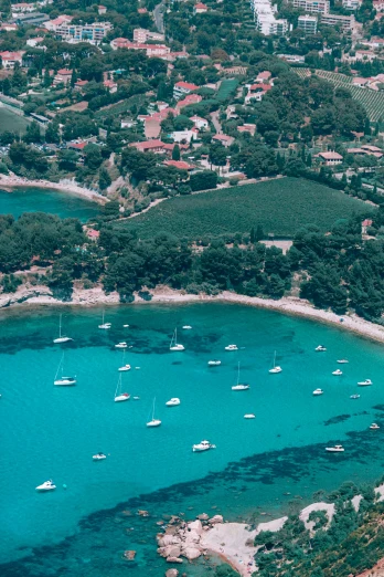 a large body of water next to a lush green hillside, by Carlo Carrà, pexels contest winner, sailboats, white beaches, 1999 photograph, square