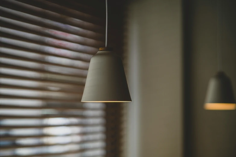 a lamp hanging from a ceiling next to a window, by Niels Lergaard, unsplash, soft light through blinds, cone shaped, pendant, close up portrait shot