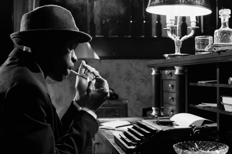 a black and white photo of a man sitting at a typewriter, inspired by Yousuf Karsh, pexels, harlem renaissance, cigars, long night cap, 1940's musician playing drums, gentleman's club lounge