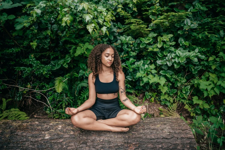 a woman meditating on a log in the woods, trending on pexels, renaissance, black young woman, avatar image, attractive photo, lotus pose