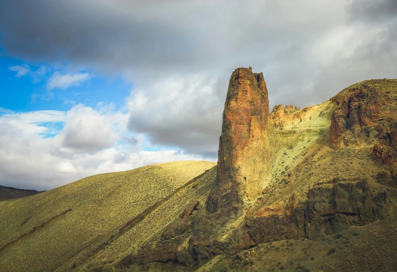 a large rock formation in the middle of a desert, by Muggur, pexels contest winner, les nabis, oregon, lead - covered spire, big island, afternoon light