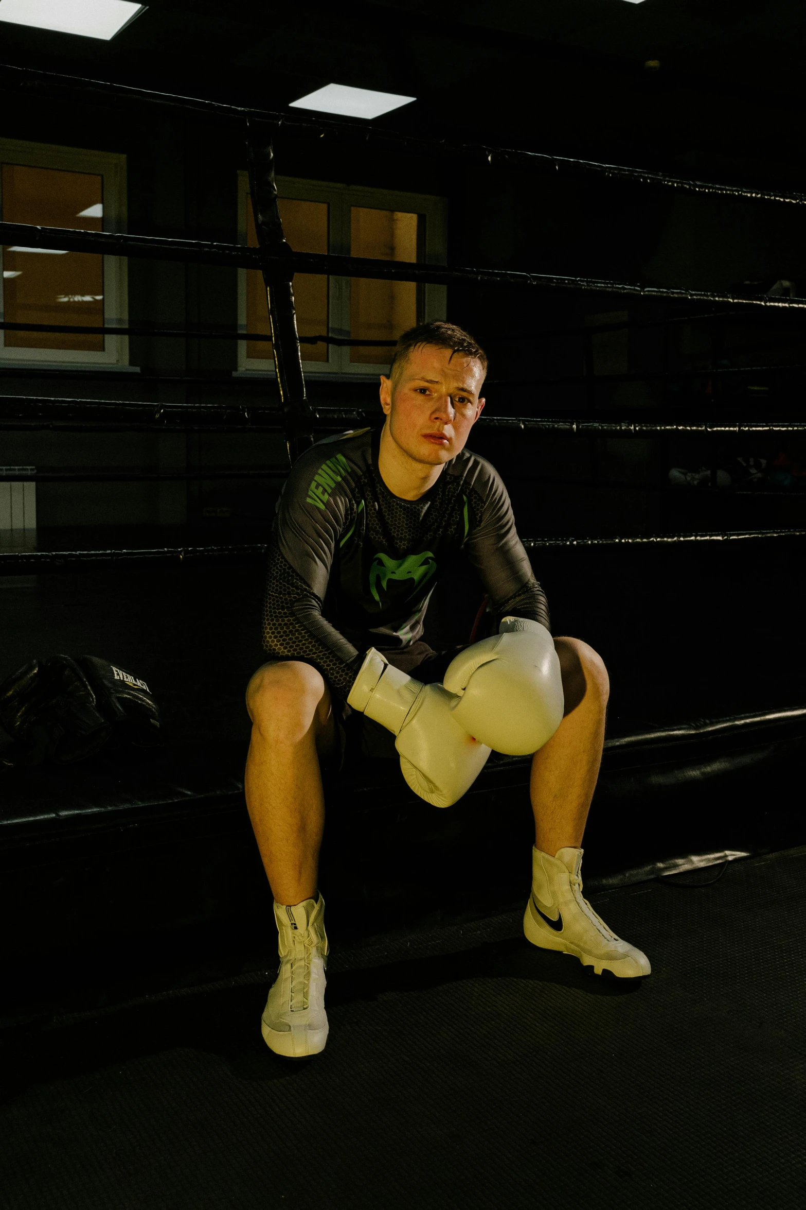 a man squatting in a boxing ring, a portrait, reddit, green light, profile image, connor hibbs, looking towards camera