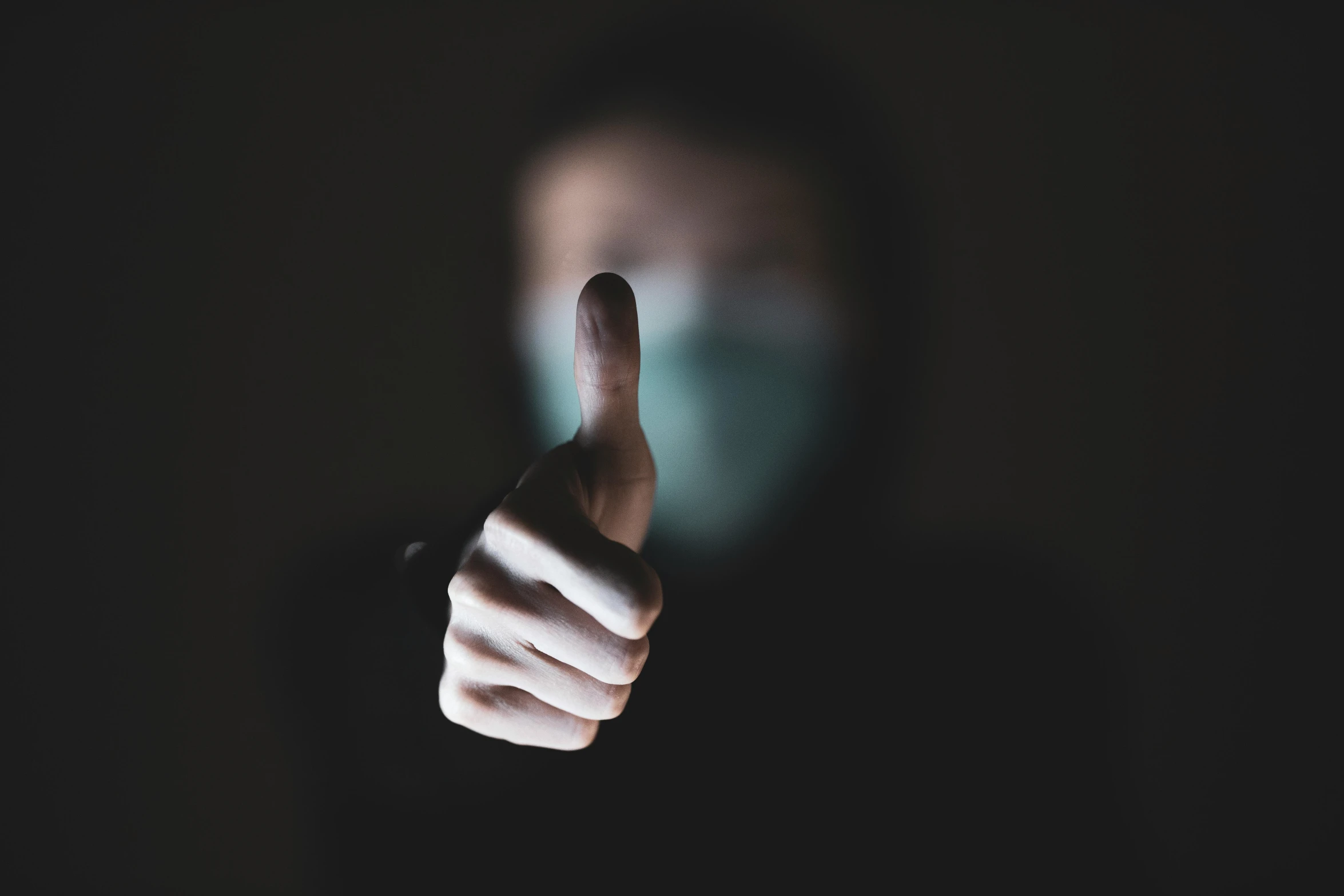 a person wearing a face mask giving a thumbs up, a picture, by Adam Marczyński, pexels contest winner, it's dark, discord profile picture, hazy, an intruder