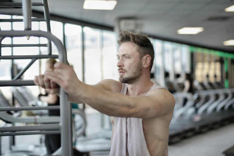 a man standing on a tread machine in a gym, by Julian Allen, lachlan bailey, profile photo, upper body image, no - text no - logo