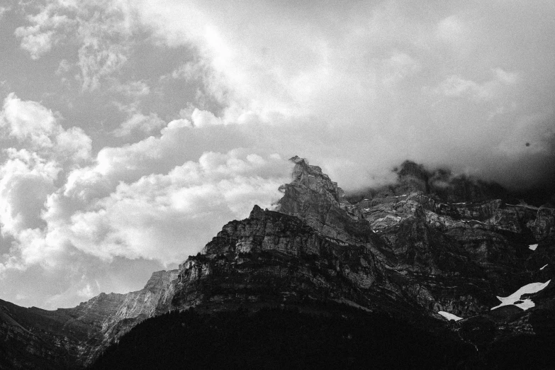 a black and white photo of a mountain range, a black and white photo, unsplash, minimalism, castle made of clouds, lauterbrunnen valley, photo pinterest, analogue photo low quality