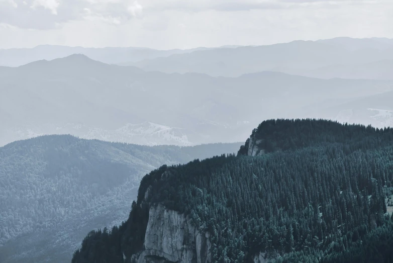 a black and white photo of a mountain range, by Adam Marczyński, pexels contest winner, tones of blue and green, black forest, cliff side, banner