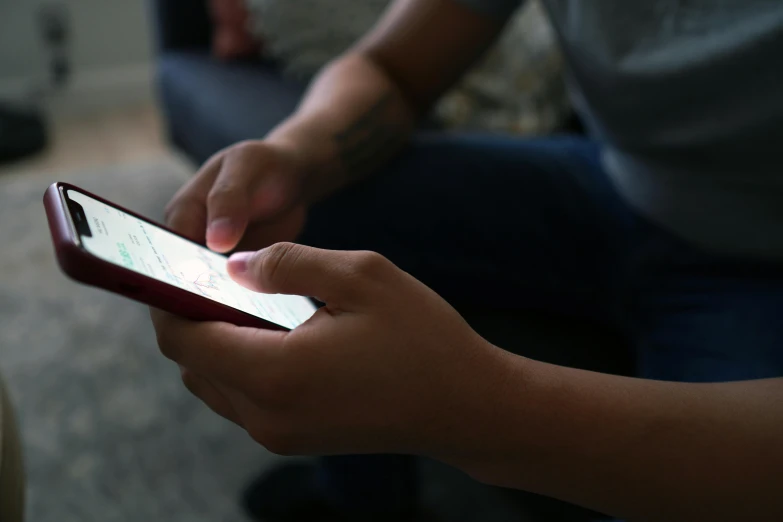 a close up of a person holding a cell phone, happening, sitting on a couch, hands straight down, lgbtq, game ready