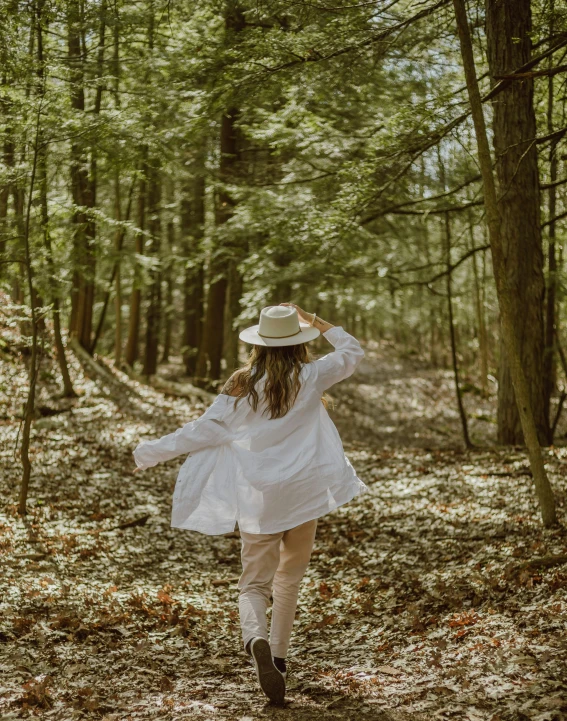 a woman in a white dress and hat walking through the woods, inspired by Asher Brown Durand, pexels contest winner, wearing a linen shirt, 🤬 🤮 💕 🎀, spring vibes, full body shots