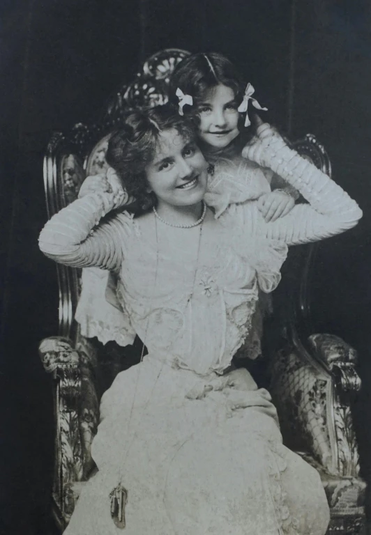 a couple of women sitting on top of a chair, an album cover, by Violet Oakley, pre-raphaelitism, large format photograph, children's, queen margherita of savoy, black - and - white photograph