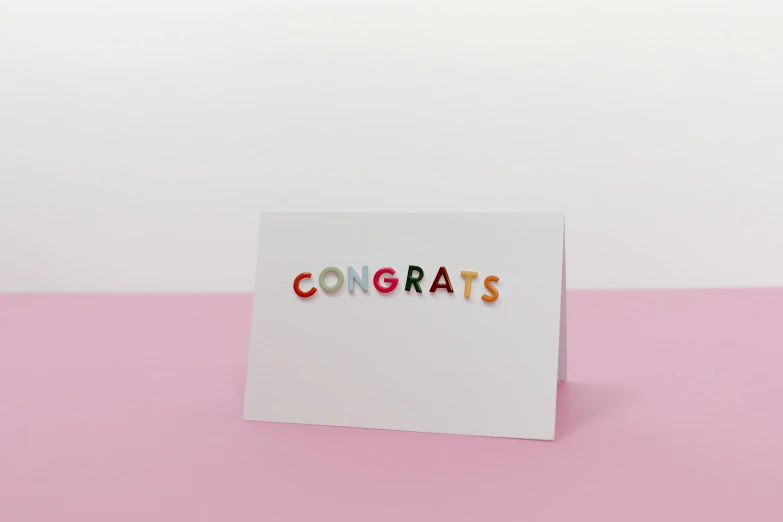 a card with the word congrats on it, letterism, rainbow tubing, embedded with gemstones, minimalist sticker, laser cut