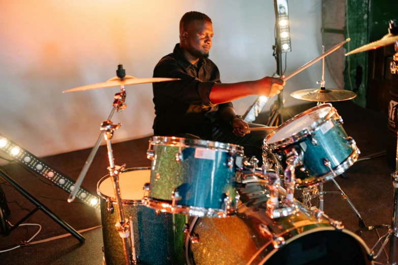 a man sitting in front of a drum set, profile image