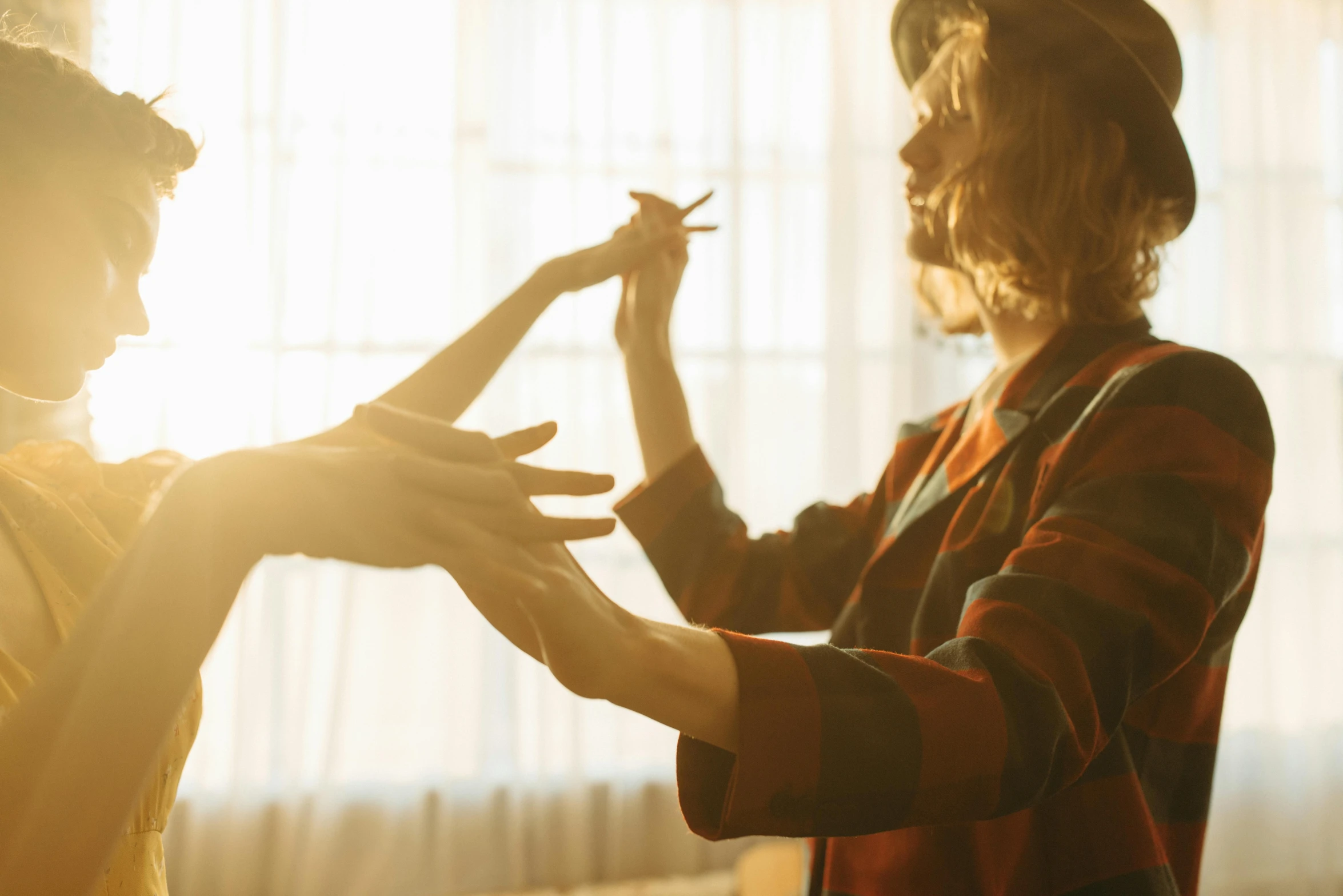 a woman putting makeup on another woman's face, by Adam Marczyński, trending on pexels, visual art, forming a burning hand spell, sunlit, dance meditation, two hands reaching for a fish