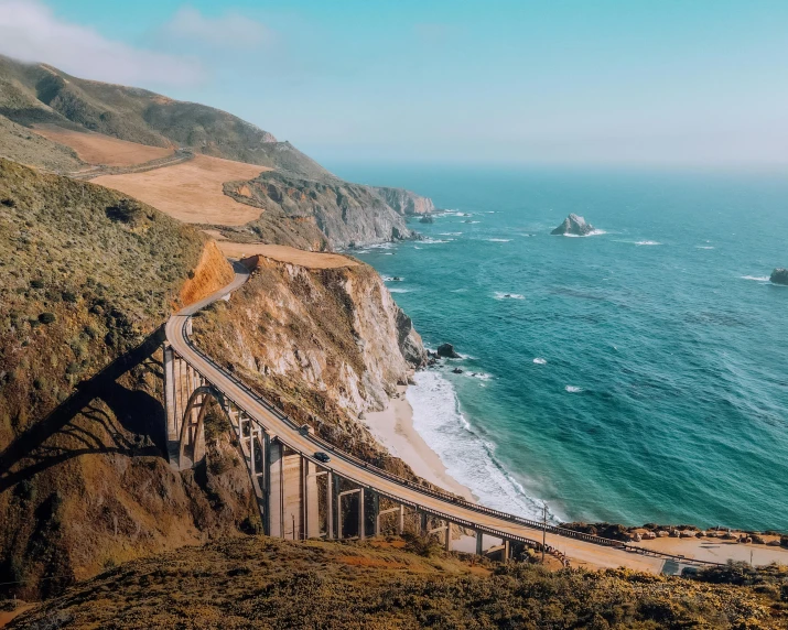 a long bridge over a large body of water, by Carey Morris, pexels contest winner, renaissance, coastal cliffs, 2 5 6 x 2 5 6 pixels, it's californication, hilly road