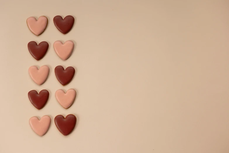 a number of hearts arranged in a row, by Emma Andijewska, trending on pexels, minimalism, brown and pink color scheme, made of glazed, advert, background image
