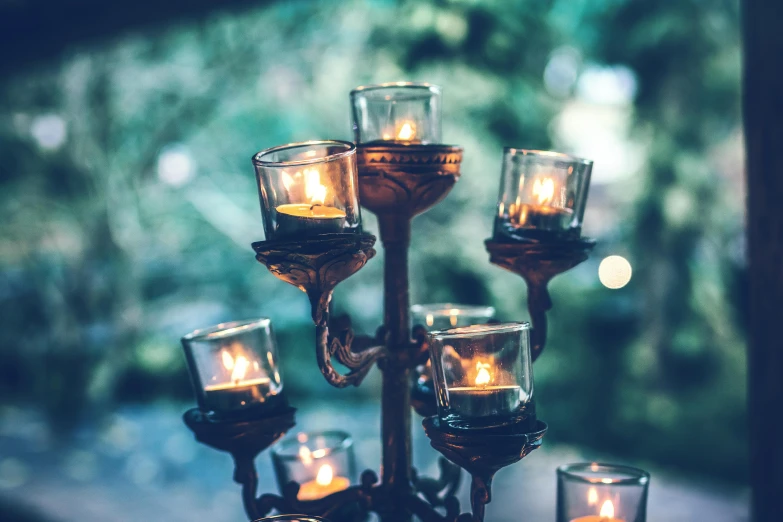 a group of candles sitting on top of a table, inspired by Elsa Bleda, unsplash, baroque, outdoor lighting, on a candle holder, retro stylised, lit from the side