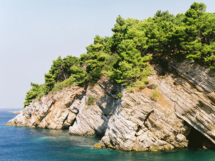 a couple of boats that are in the water, unsplash, romanticism, detailed trees and cliffs, slim aarons, piroca, pine tree