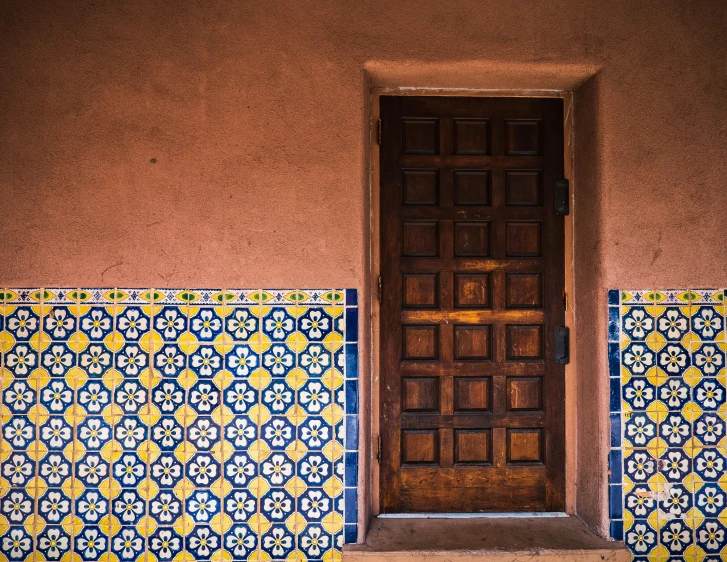 a door that is on the side of a building, inspired by Alberto Morrocco, unsplash contest winner, arts and crafts movement, floor tiles, tucson arizona, square, multicolored