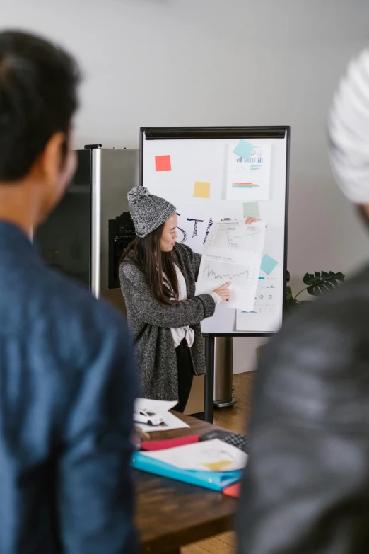 a woman giving a presentation to a group of people, trending on unsplash, industrial design blueprint, curated collections, whiteboard, straight on portrait