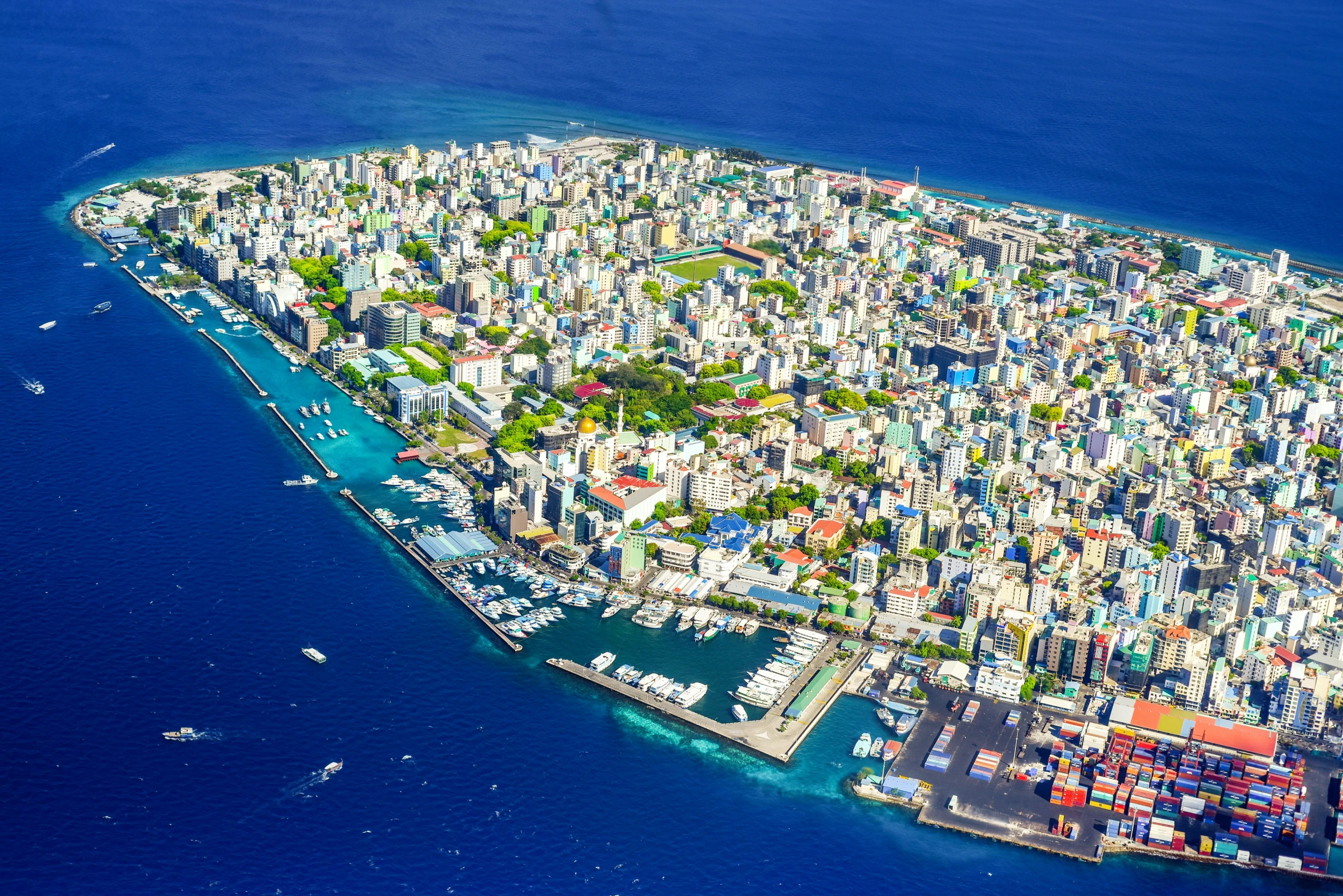 a small island in the middle of the ocean, by Sam Dillemans, pexels contest winner, hurufiyya, aerial view of a city, maldives in background, slide show, cyprus