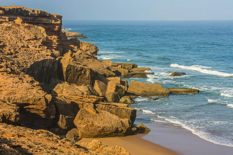 a man standing on top of a cliff next to the ocean, les nabis, red sandstone natural sculptures, dakar, today\'s featured photograph 4k, zoomed in