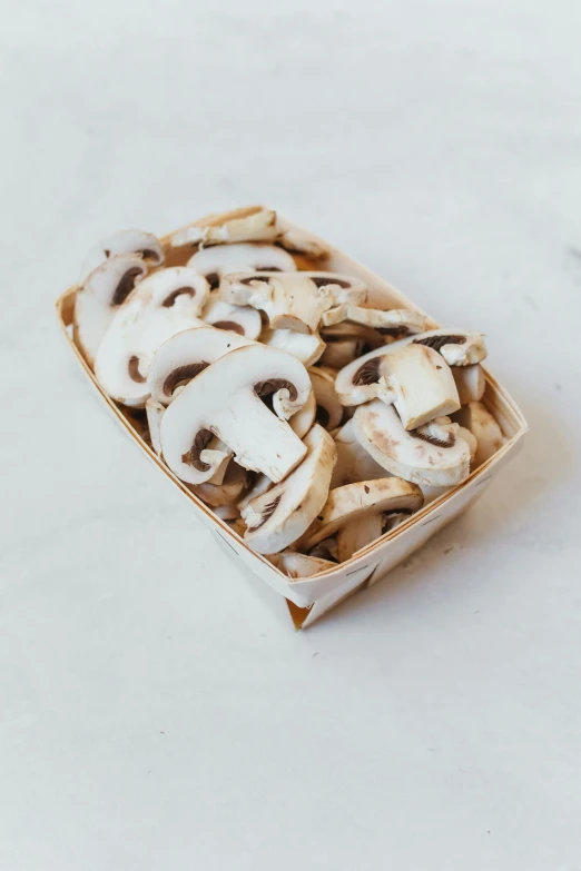 a box of mushrooms sitting on top of a table, white with chocolate brown spots, natural soft rim light, savory, petite