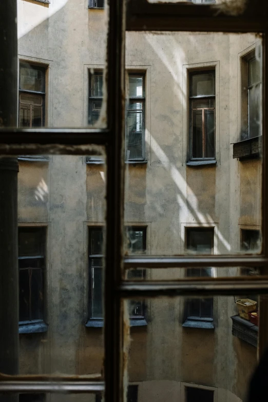 a view of a building through a window, a picture, inspired by André Kertész, unsplash contest winner, serge marshennikov, late afternoon light, tenement buildings, soviet interior